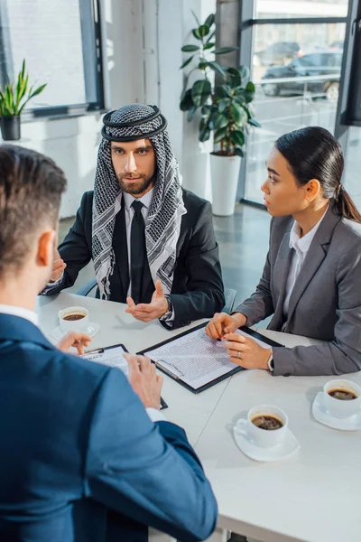 Multiethnic business partners on meeting with translator in office — Stock Photo