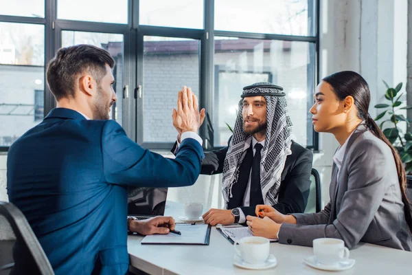 Positive multikulturelle Geschäftspartner geben HighFive bei Treffen mit Übersetzer im Amt — Stockfoto
