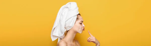 Side view of young woman in facial mask pointing with finger at lips, panoramic shot — Stock Photo