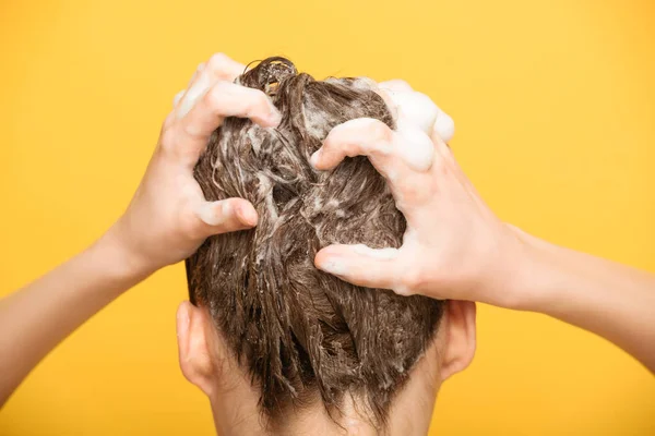 Rückseite der Frau beim Haarewaschen mit Shampoo isoliert auf gelb — Stockfoto