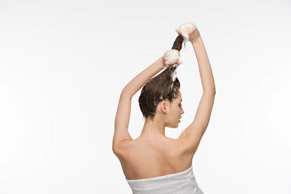 Вид сзади молодая женщина мыть длинные волосы изолированы на белом — стоковое фото