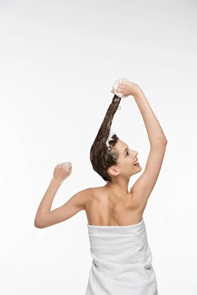 Jeune femme lavant les cheveux longs tout en regardant isolé sur blanc — Photo de stock