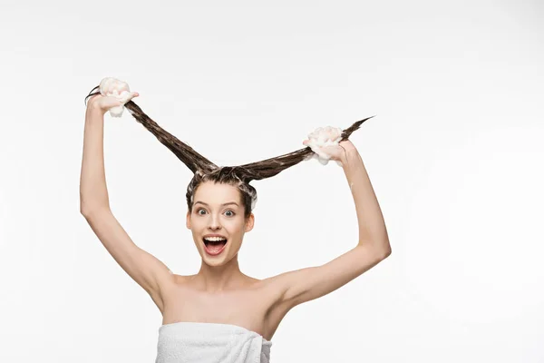 Menina animado se divertindo ao lavar o cabelo longo isolado no branco — Fotografia de Stock