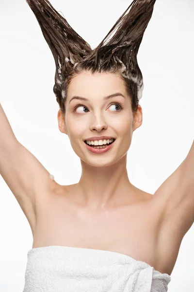 Glückliches Mädchen schaut weg, während es lange Haare isoliert auf weiß wäscht — Stockfoto