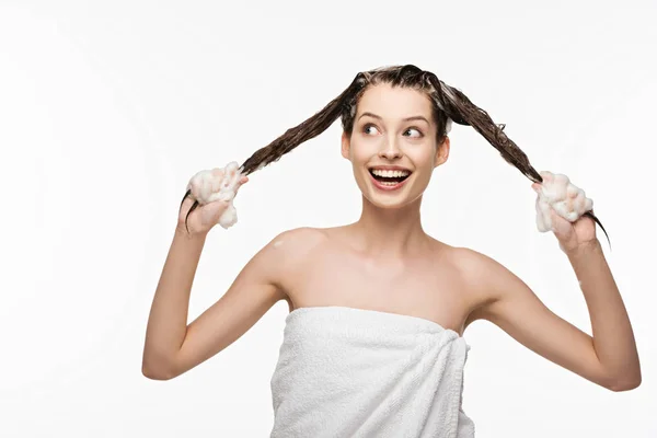 Cheerful girl having fun while washing long hair isolated on white — Stock Photo