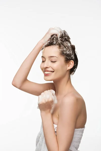 Fille souriante laver les cheveux avec les yeux fermés isolé sur blanc — Photo de stock