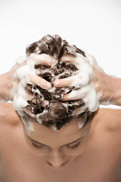 Junge Frau wäscht Haare mit Shampoo isoliert auf weiß — Stockfoto