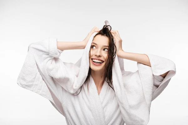 Felice ragazza pulire i capelli puliti bagnati con spugna bianca asciugamano mentre guardando lontano isolato su bianco — Foto stock