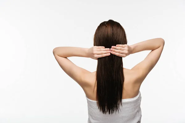 Vista posterior de la mujer joven tocando el pelo liso limpio aislado en blanco - foto de stock