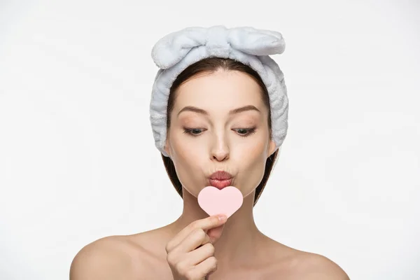 Menina atraente beijando esponja cosmética em forma de coração isolado no branco — Fotografia de Stock
