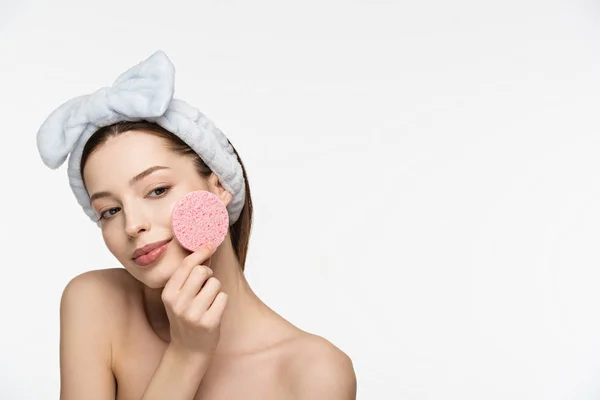 Menina sorrindo segurando esponja cosmética perto do rosto isolado no branco — Fotografia de Stock