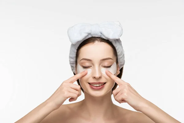 Menina sorridente com olhos fechados tocando manchas oculares isoladas no branco — Fotografia de Stock