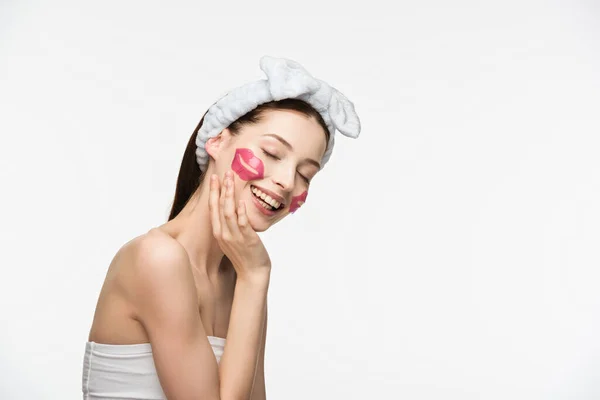 Smiling girl with lip-shaped collagen patches touching face isolated on white — Stock Photo