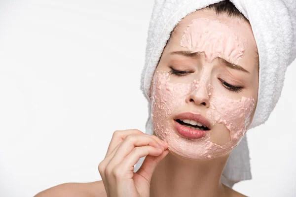 Menina descontente removendo a máscara de descascamento do rosto isolado no branco — Fotografia de Stock