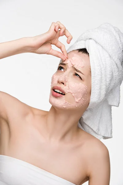 Dissatisfied girl removing scrab mask from face while looking at camera isolated on white — Stock Photo