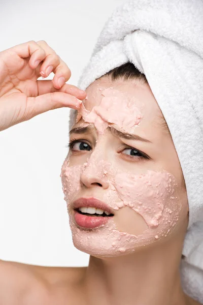 Displeased girl removing scrab mask from face while looking at camera isolated on white — Stock Photo