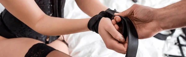 Panoramic shot of man touching tie on hands of woman — Stock Photo