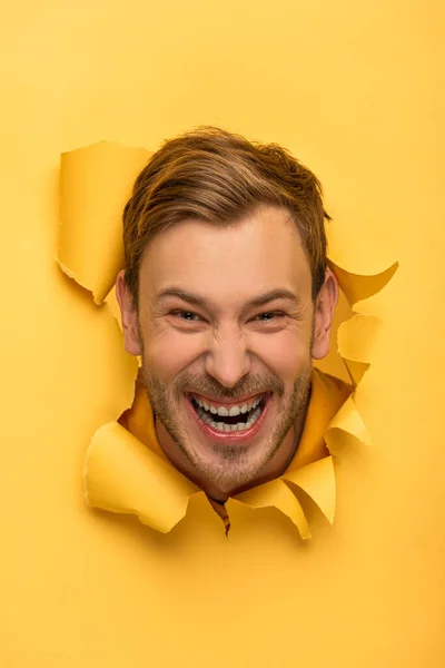 Louco bonito homem com cabeça no buraco de papel amarelo — Fotografia de Stock