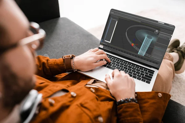 Selective focus of 3d artist working with project on laptop on couch in office — Stock Photo