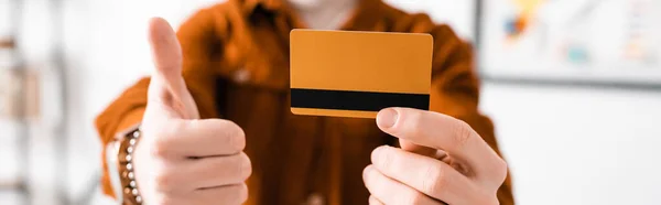 Cropped view of 3d artist holding credit card and shoving thumb up, panoramic shot — Stock Photo