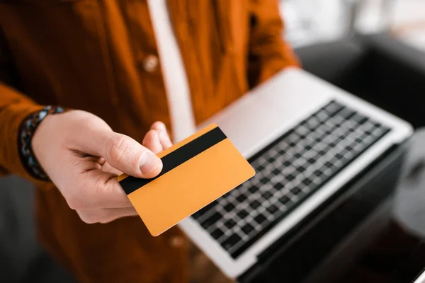 Foco seletivo do artista 3d segurando cartão de crédito e laptop com tela em branco — Fotografia de Stock