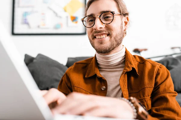 Selektiver Fokus eines lächelnden 3D-Künstlers, der im Büro am Laptop arbeitet — Stockfoto