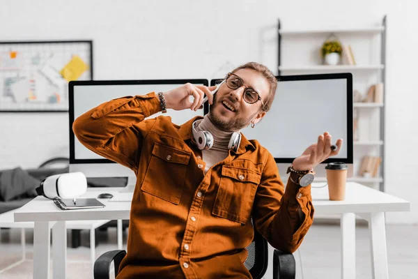 Lächelnder 3D-Künstler spricht auf Smartphone und hält Stift des Grafik-Tablets im Büro — Stockfoto