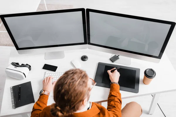 Vista aérea de artista 3d trabajando con tabletas gráficas y computadoras en la mesa - foto de stock