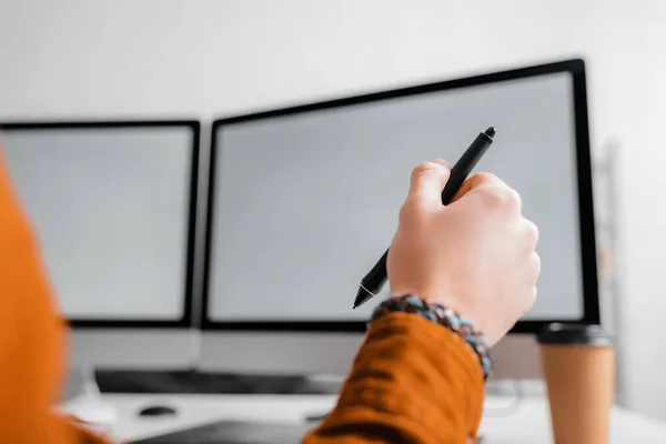 Cropped view of 3d artist holding stylus of graphics tablet while working at table — Stock Photo