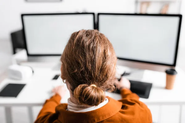 Back view of 3d artist working with graphics tablet and computers at table in office — Stock Photo