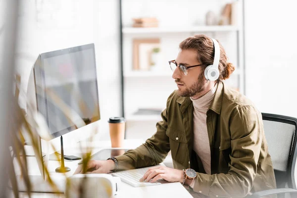 Foco seletivo do artista 3d em fones de ouvido projeto de renderização de design 3d em computadores à mesa — Fotografia de Stock