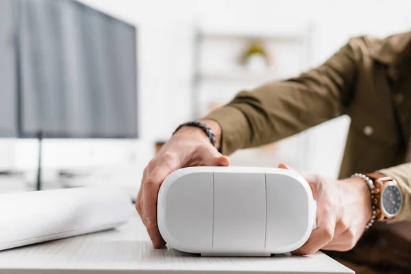 Vue recadrée de l'artiste 3D prenant casque de réalité virtuelle de la table — Photo de stock