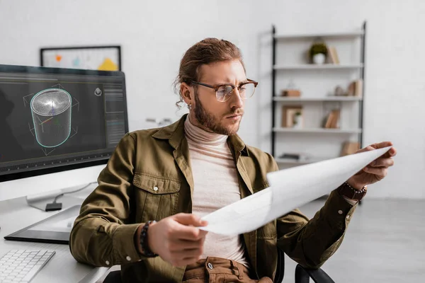 3d artista olhando para o blueprint enquanto trabalhava no projeto de design 3d no escritório — Fotografia de Stock