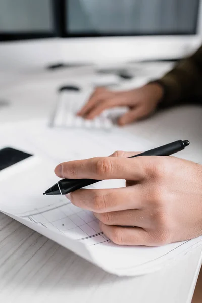 Selektiver Fokus des 3D-Künstlers, der den Stift des Grafiktablets in der Nähe der Blaupause hält, während er am Tisch arbeitet — Stockfoto