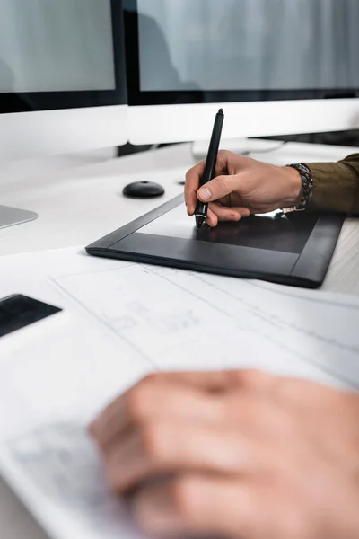 Mise au point sélective de l'artiste 3D en utilisant une tablette graphique près du plan tout en travaillant à la table — Photo de stock