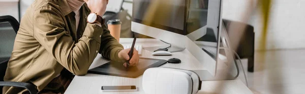 Selective focus of 3d artist using graphics tablet near vr headset, smartphone and computers on table, panoramic shot — Stock Photo