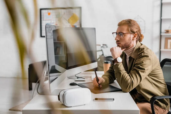 Selective focus of 3d artist using graphics tablet near vr headset, smartphone and computers on table — Stock Photo