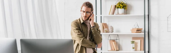 Panoramic shot of pensive 3d artist looking at computer monitors in office — Stock Photo