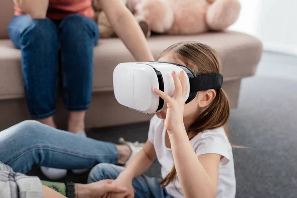 Kid using vr headset near mothers in living room — Stock Photo