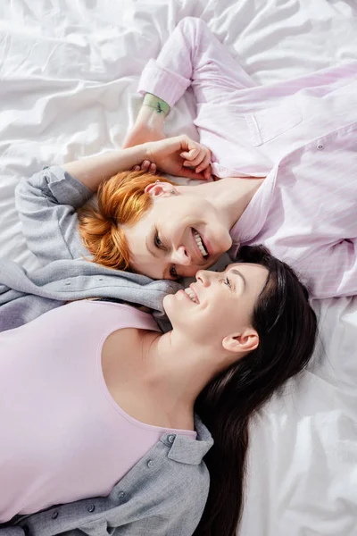 Top view of same sex couple smiling at each other on bed — Stock Photo