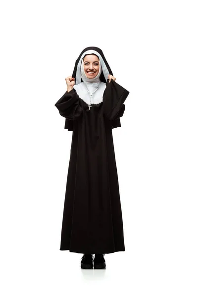 Красивая молодая возбужденная монахиня, стоящая изолированная на белом — стоковое фото