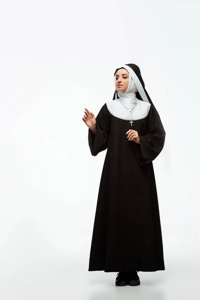 Schöne junge glückliche Nonne steht auf weiß — Stockfoto