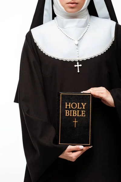 Vista recortada de monja sosteniendo la sagrada Biblia aislada en blanco - foto de stock