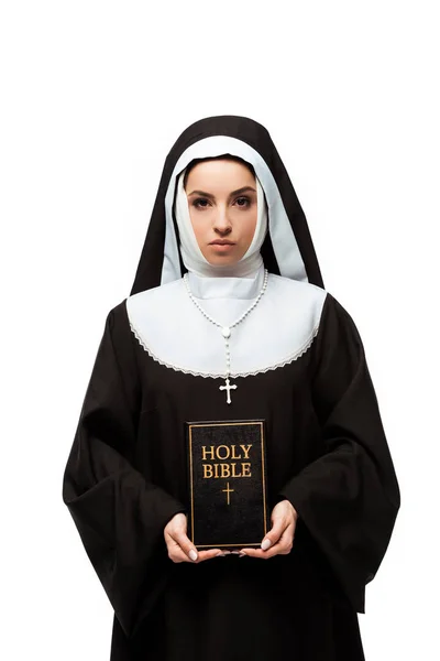 Beautiful serious nun holding holy bible isolated on white — Stock Photo