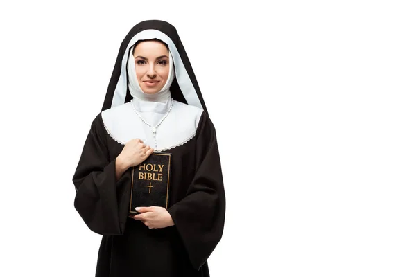 Schöne glückliche Nonne hält heilige Bibel isoliert auf weiß — Stockfoto