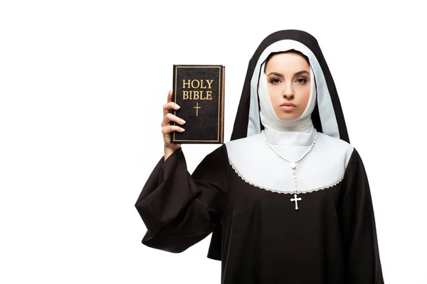 Monja hermosa confiada sosteniendo la biblia santa aislada en blanco - foto de stock