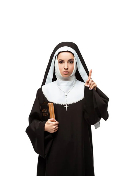 Schöne Nonne hält Bibel in der Hand und zeigt mit Idee auf weiß isoliert — Stockfoto