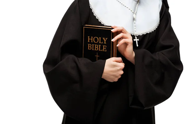 Vista recortada de monja sosteniendo la sagrada Biblia aislada en blanco - foto de stock