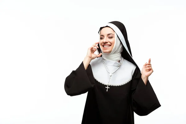 Hermosa monja feliz hablando en el teléfono inteligente aislado en blanco - foto de stock