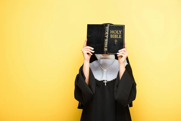 Jovem freira leitura bíblia sagrada no cinza — Fotografia de Stock